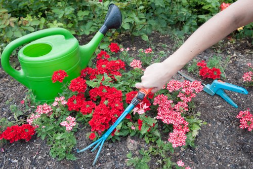 A gardener wearing protective equipment while inspecting tools and plants